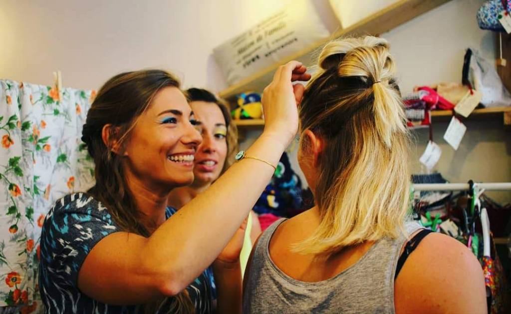 girls fixing each others hair and smiling