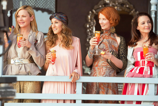a scene from tv show Sex in the City showing the 4 main characters with drinks in their hands
